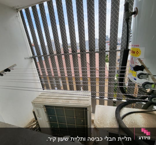 מזגן חיצוני עם צינורות ומתקן כביסה